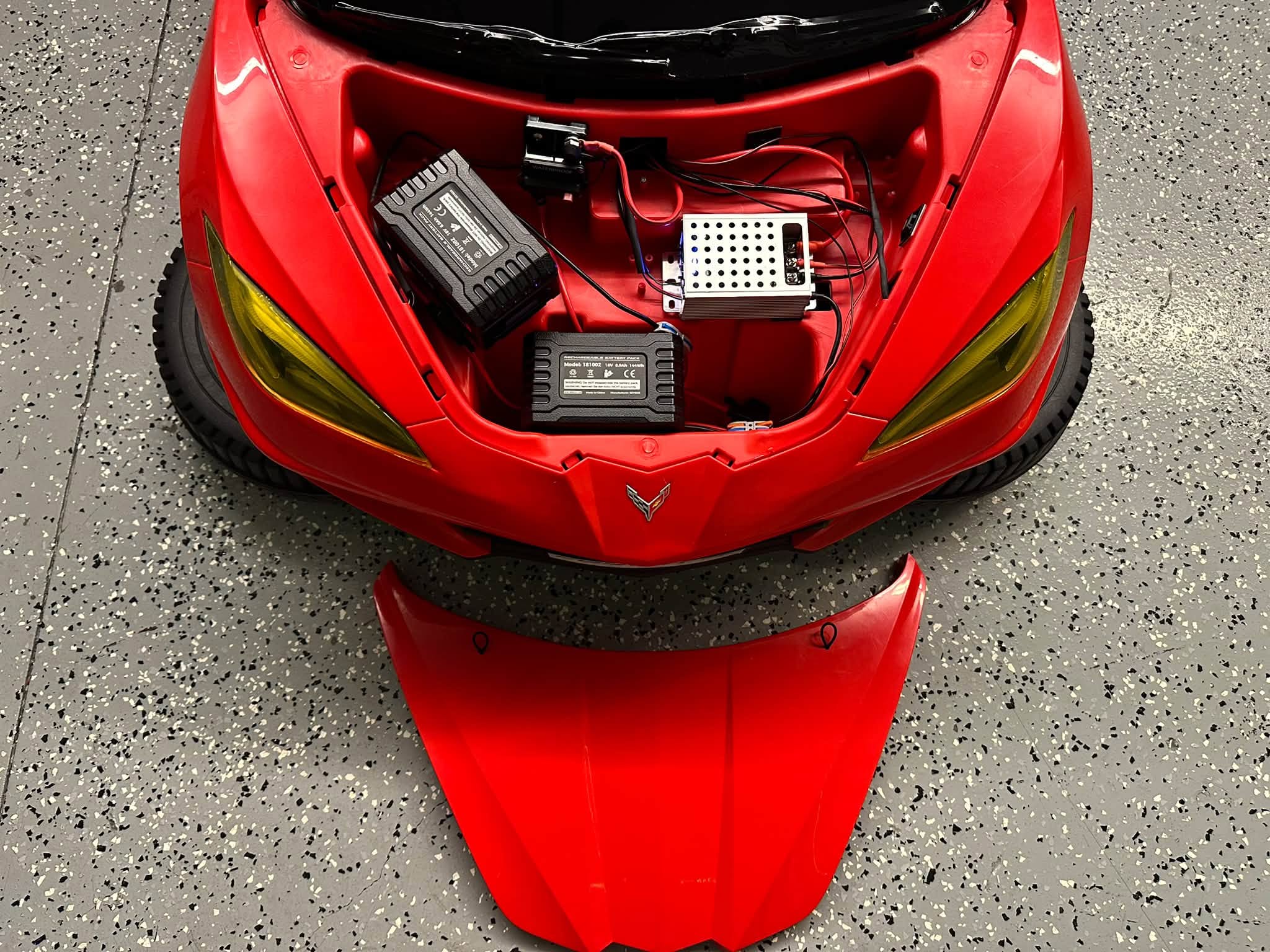Front compartment of the Corvette ride-on showing batteries, wiring, and voltage regulation equipment